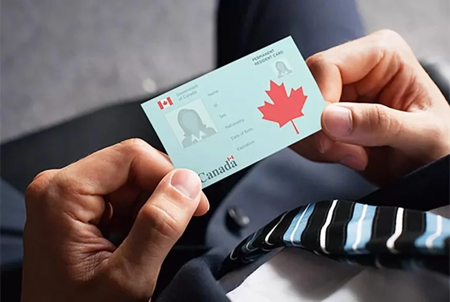 Permanent resident card held in hand